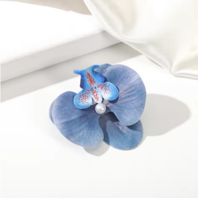 Pince Hawaienne fleur bleue océan portée de côté sur chignon naturel