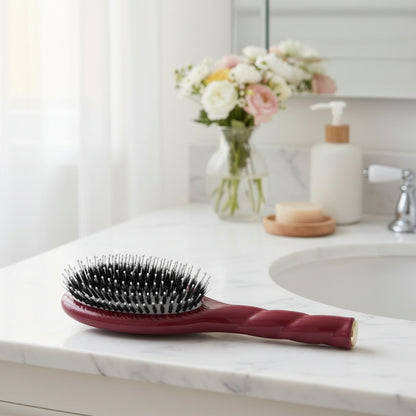 brosse cheveux bordeaux posée sur meuble de salle de bain