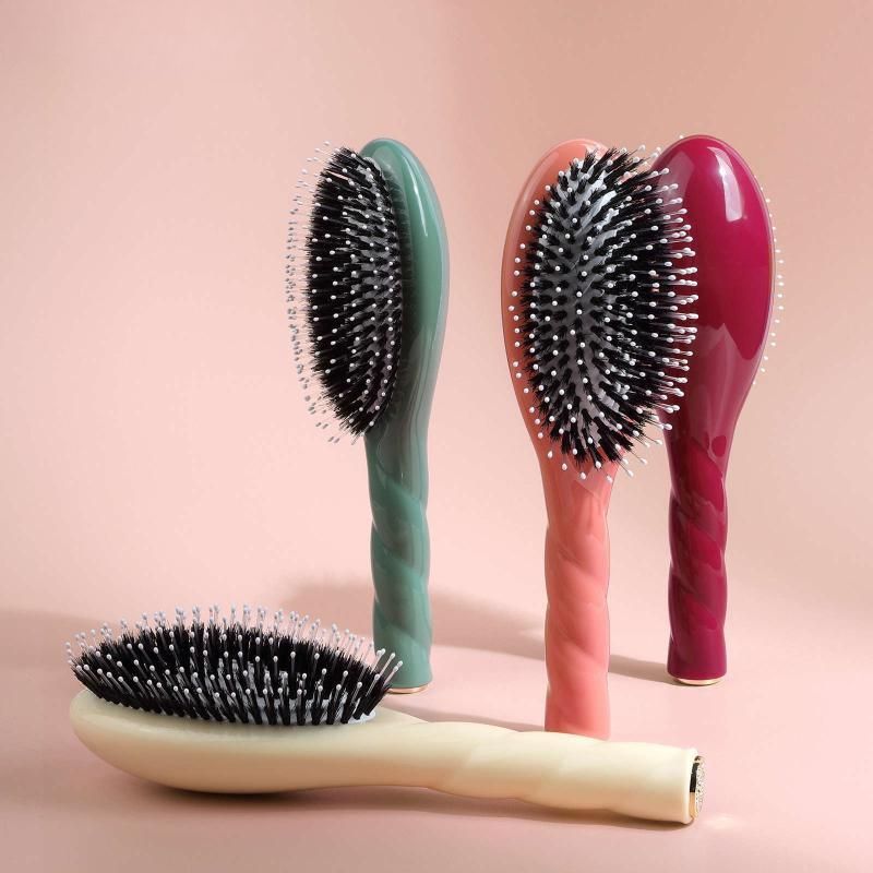 brosse cheveux multicolore présentée en quatre teintes sur fond rose